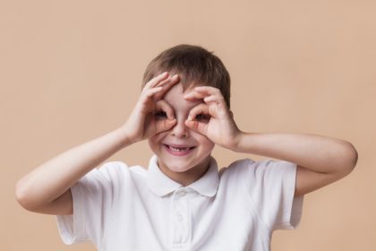portrait-happy-boy-looking-through-fingers-as-binoculars_23-2148197439
